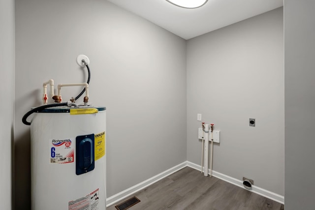 604 W 4th Ave, Hohenwald, TN 38462 - washroom featuring dark wood-type flooring, washer hookup, water heater, and electric dryer hookup