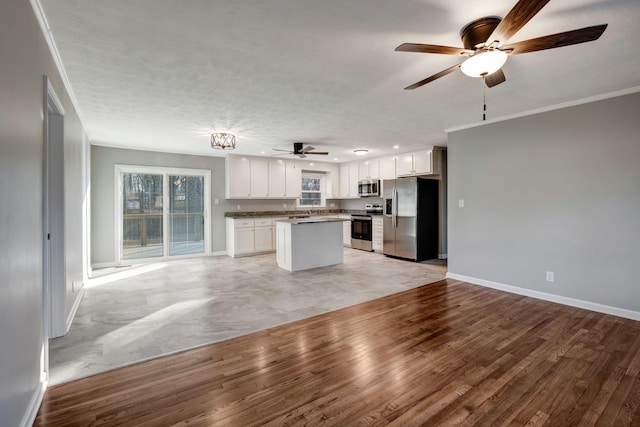 604 W 4th Ave, Hohenwald, TN 38462 - kitchen with white cabinetry, ornamental molding, stainless steel appliances, and a kitchen island