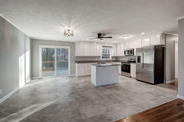 604 W 4th Ave, Hohenwald, TN 38462 - kitchen with white cabinetry, ornamental molding, stainless steel appliances, and ceiling fan