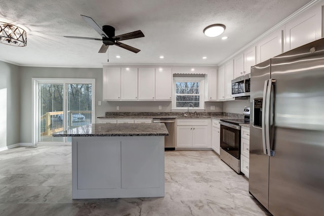 604 W 4th Ave, Hohenwald, TN 38462 - kitchen featuring a kitchen island, sink, white cabinets, dark stone counters, and stainless steel appliances