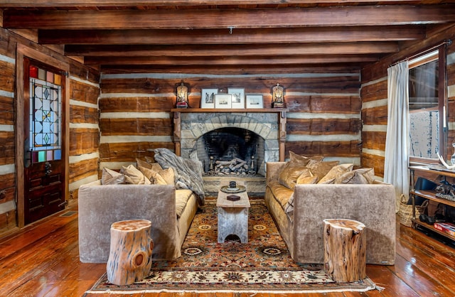 living room with beamed ceiling, a fireplace, wood-type flooring, and wooden walls