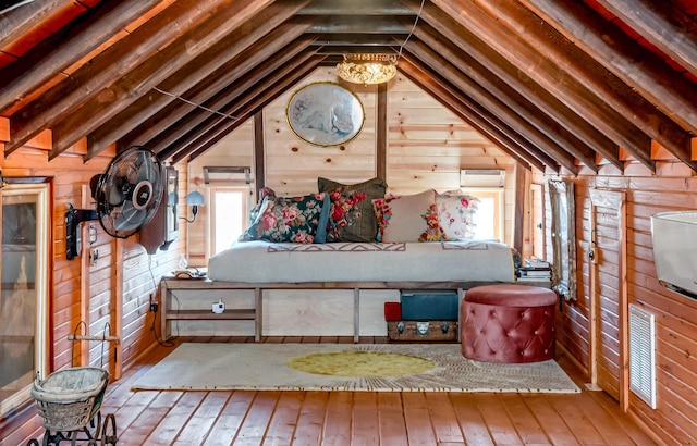 unfurnished bedroom featuring vaulted ceiling with beams, hardwood / wood-style floors, and wooden walls