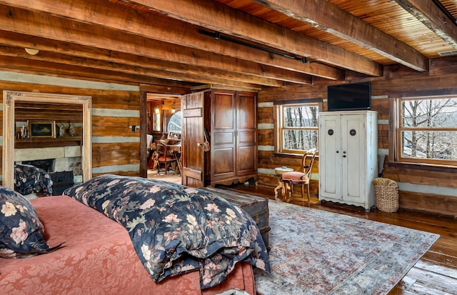 bedroom with beamed ceiling, wood ceiling, wooden walls, and hardwood / wood-style flooring