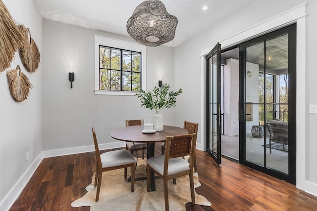 dining space with dark wood-type flooring and an inviting chandelier