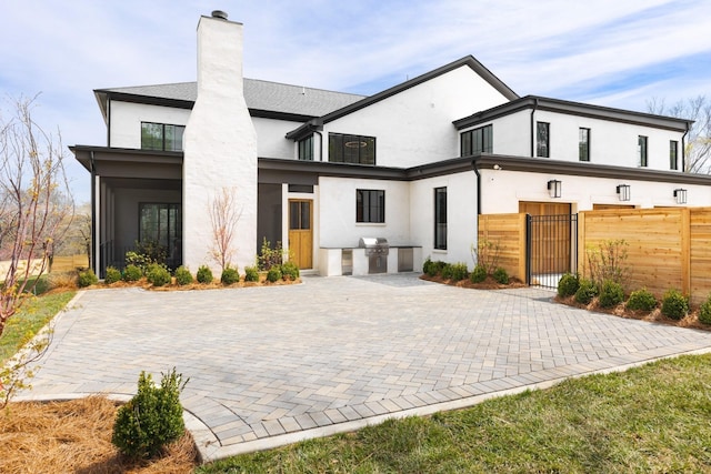 rear view of house featuring an outdoor kitchen and a patio area