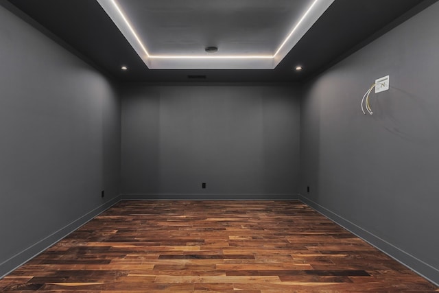 unfurnished room featuring dark hardwood / wood-style floors and a raised ceiling