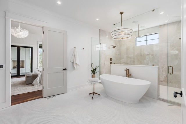 bathroom featuring an inviting chandelier, independent shower and bath, french doors, and tile walls