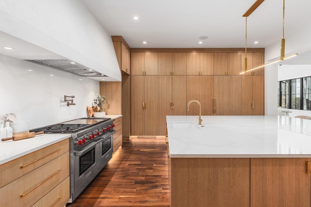 kitchen with sink, hanging light fixtures, light stone countertops, custom range hood, and range with two ovens