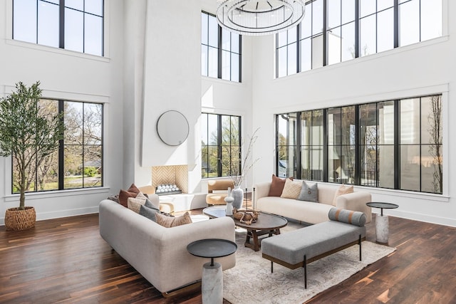 living room with plenty of natural light, dark hardwood / wood-style floors, and a chandelier