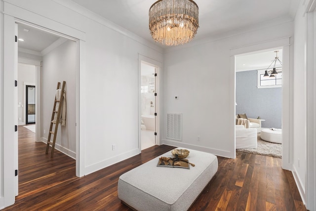 interior space featuring an inviting chandelier, dark hardwood / wood-style flooring, and crown molding