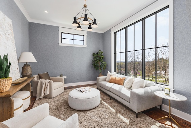 living room with crown molding, wood-type flooring, and a chandelier