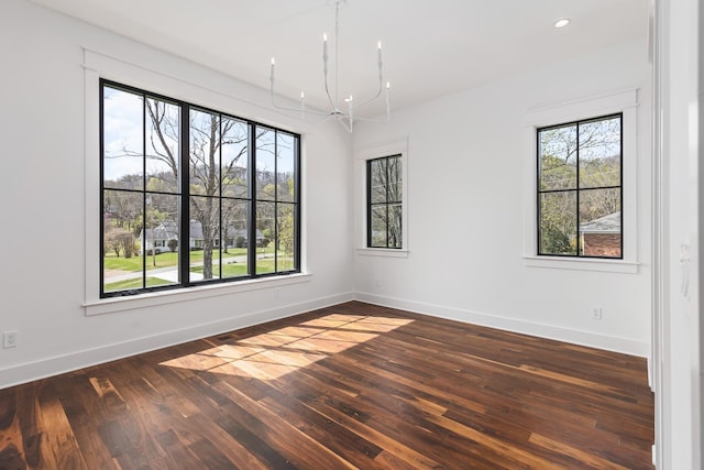 unfurnished room with dark wood-type flooring and an inviting chandelier