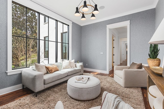 living room featuring dark hardwood / wood-style flooring, crown molding, and a chandelier