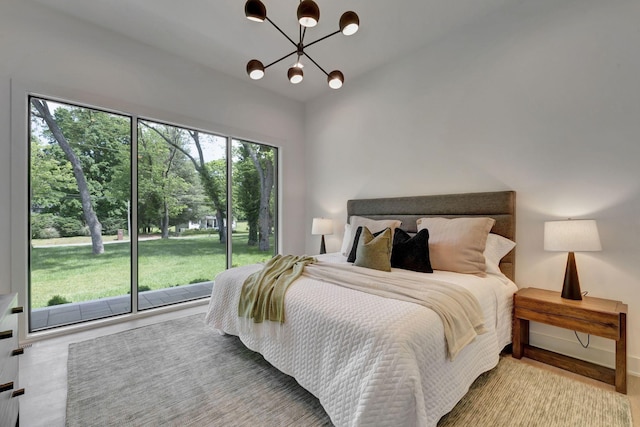 bedroom featuring access to exterior and a notable chandelier