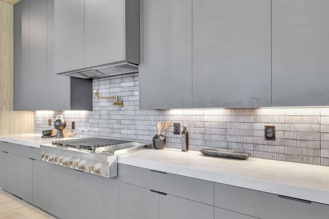 kitchen featuring stainless steel gas cooktop, gray cabinetry, and decorative backsplash