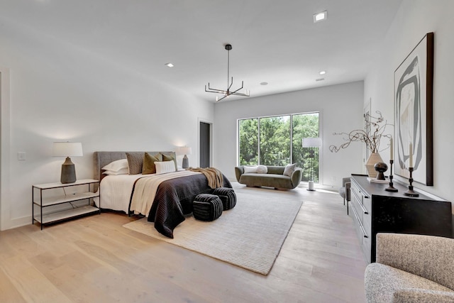 bedroom with an inviting chandelier, access to exterior, and light wood-type flooring