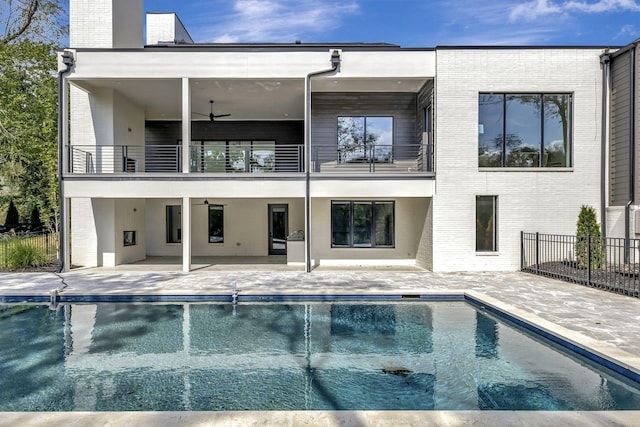 back of house with a balcony, ceiling fan, and a patio area