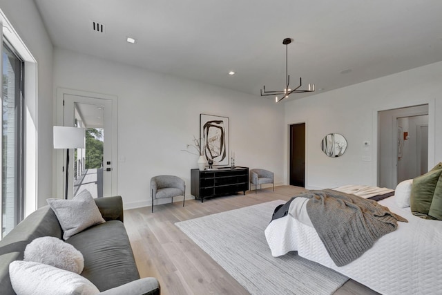 bedroom featuring light hardwood / wood-style floors and a chandelier