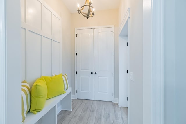 mudroom with a chandelier and light wood-type flooring