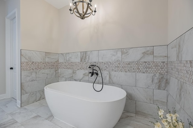 bathroom with an inviting chandelier, tile walls, and a washtub