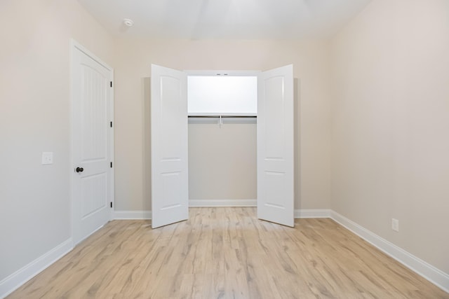 unfurnished bedroom featuring light hardwood / wood-style flooring and a closet