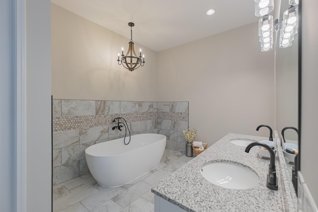 bathroom featuring vanity, a bathtub, tile walls, and a notable chandelier