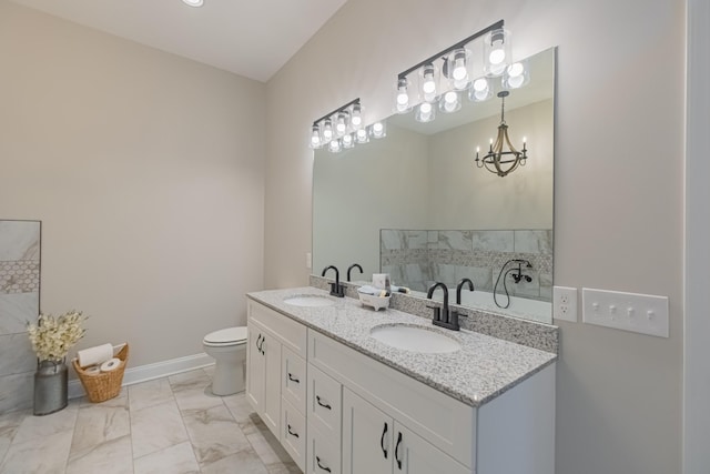 bathroom featuring vanity, toilet, and an inviting chandelier