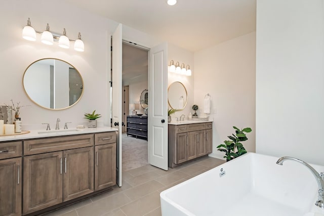 bathroom featuring tile patterned flooring, vanity, and a tub