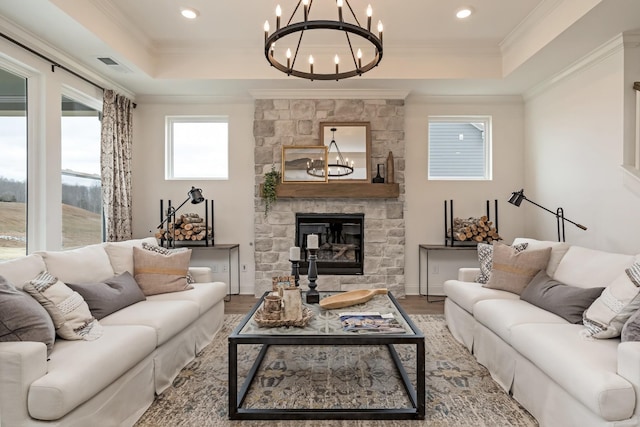 living room featuring hardwood / wood-style floors, a tray ceiling, and a fireplace