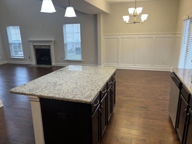 kitchen with dishwasher, light stone countertops, a healthy amount of sunlight, and pendant lighting