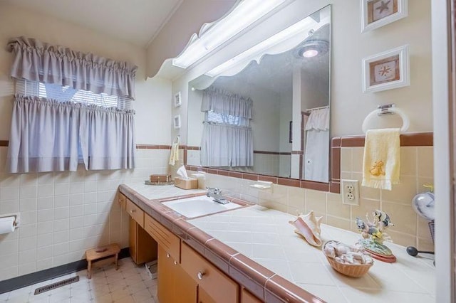 bathroom with vanity and tile walls