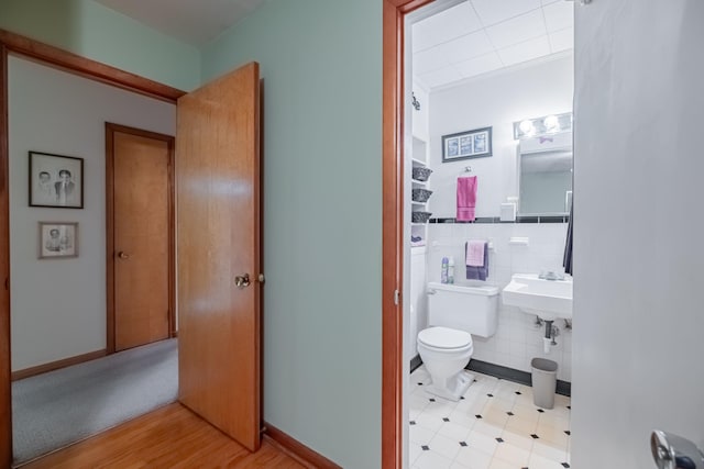 bathroom featuring tile walls and toilet