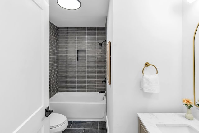 full bathroom featuring vanity, tiled shower / bath, tile patterned floors, and toilet