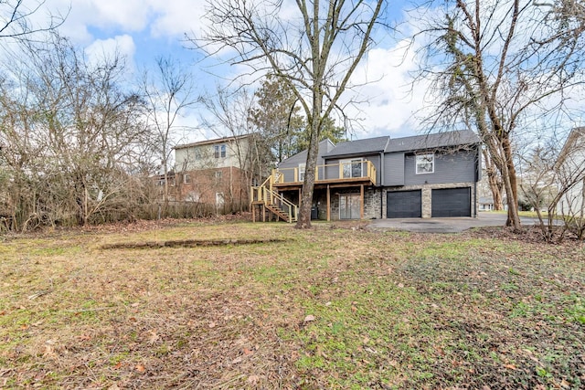 exterior space with a garage, a deck, and a lawn