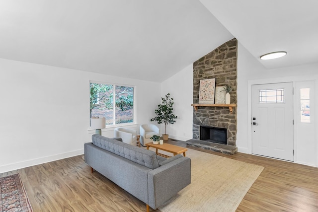 living room featuring high vaulted ceiling, a fireplace, and hardwood / wood-style floors