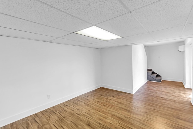 basement featuring wood-type flooring and a drop ceiling