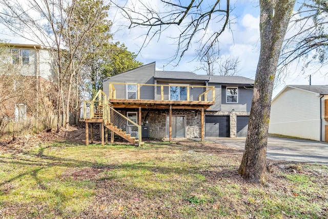 back of house featuring a garage, a lawn, and a deck