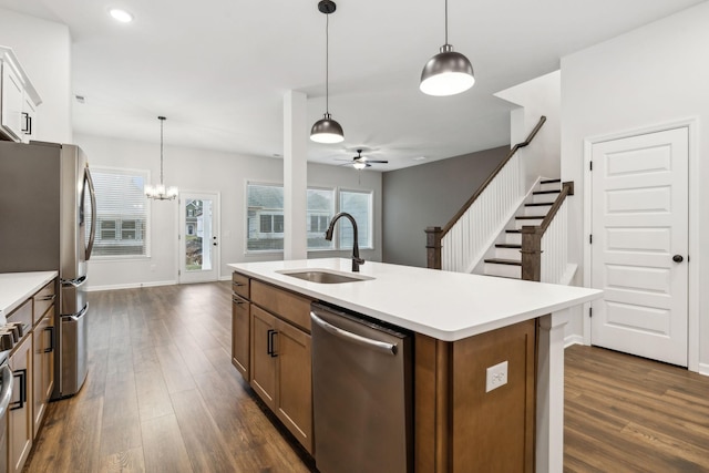 kitchen with hanging light fixtures, sink, an island with sink, and appliances with stainless steel finishes