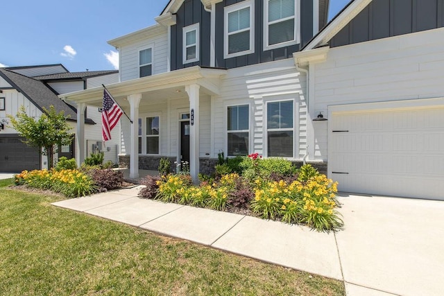 510 Dovetail Dr, Smyrna, TN 37167 - view of front of home featuring board and batten siding, a garage, covered porch, stone siding, and a front lawn