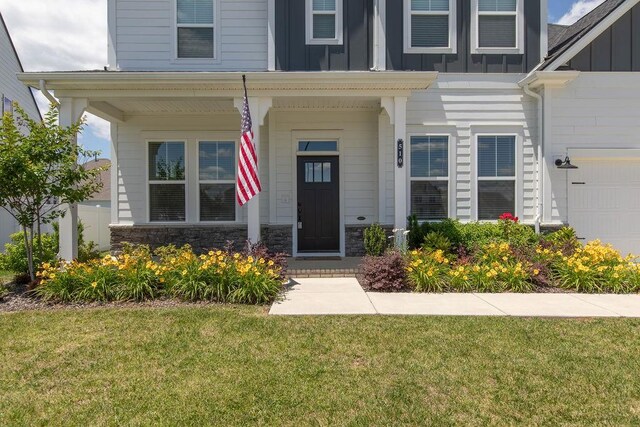 510 Dovetail Dr, Smyrna, TN 37167 - doorway to property with board and batten siding, a lawn, a garage, and stone siding