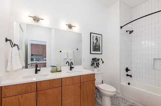 full bathroom featuring vanity, tiled shower / bath, and toilet