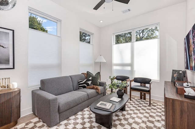 living room with ceiling fan and light hardwood / wood-style flooring