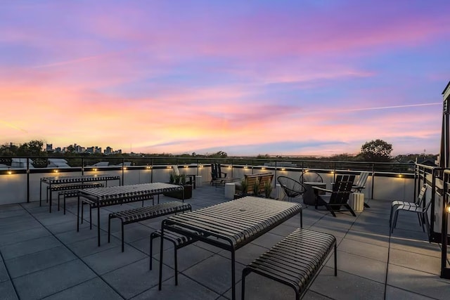 patio terrace at dusk featuring a water view