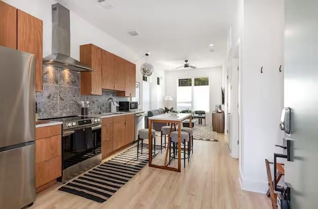 kitchen with sink, tasteful backsplash, hanging light fixtures, stainless steel appliances, and exhaust hood