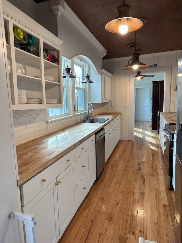 kitchen with butcher block countertops, sink, white cabinets, light hardwood / wood-style floors, and stainless steel appliances