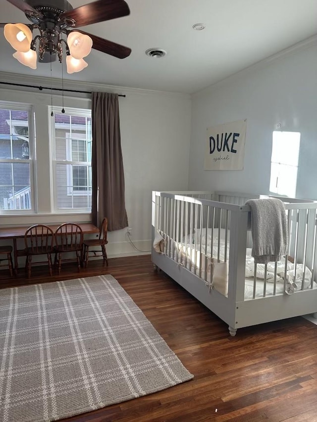 unfurnished bedroom featuring crown molding, dark wood-type flooring, and ceiling fan