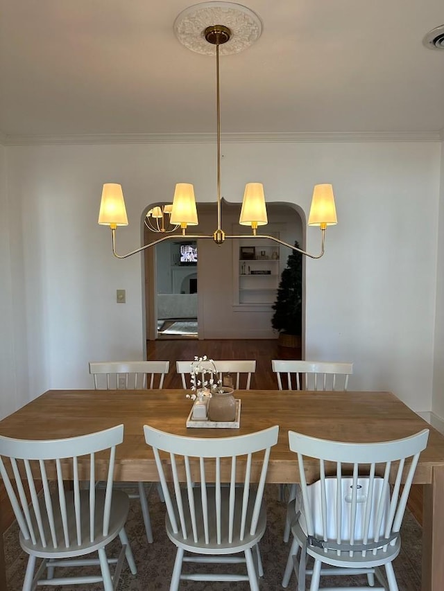 dining area featuring crown molding and dark wood-type flooring