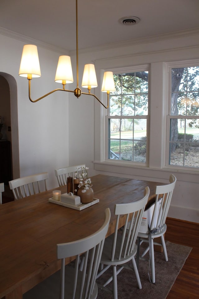 dining room featuring ornamental molding and dark hardwood / wood-style floors