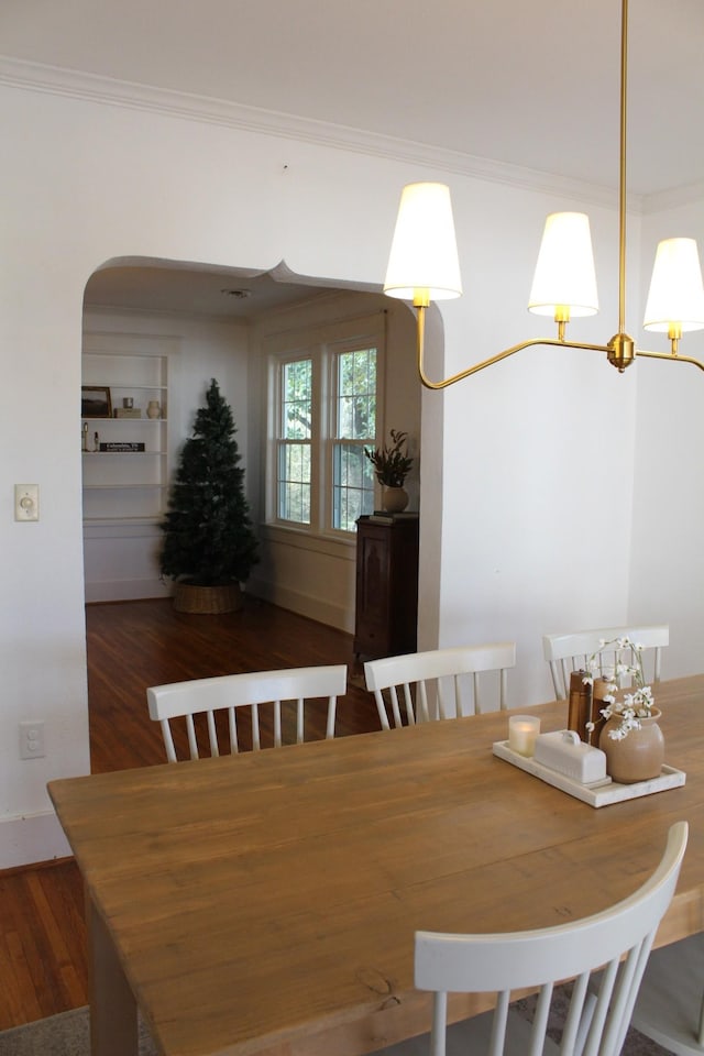 dining space featuring crown molding and dark wood-type flooring