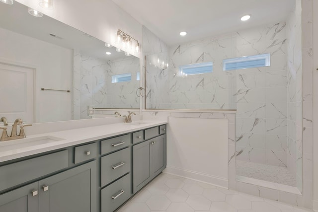 bathroom featuring tiled shower and vanity